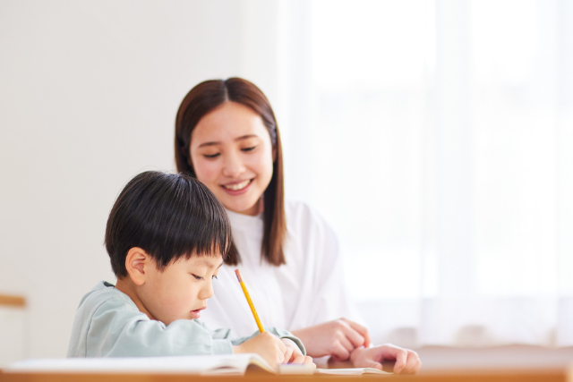 A mother is accompanying her son with dyslexia while he does his homework.